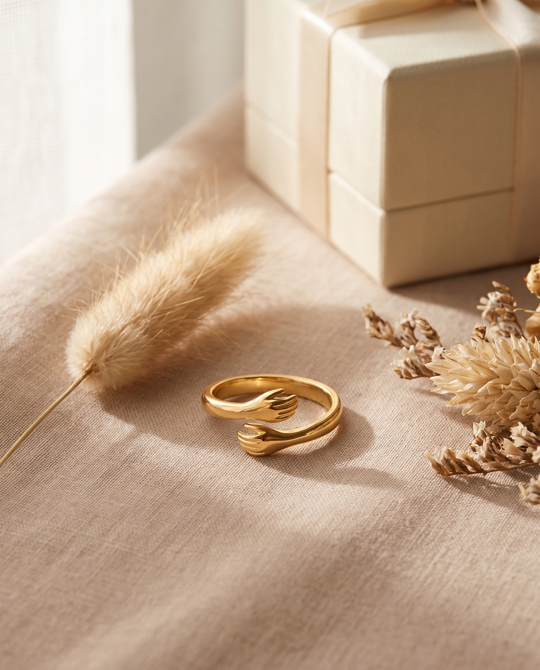 Bague Câlin ajustable dorée, deux mains enlacées, posée sur lin beige