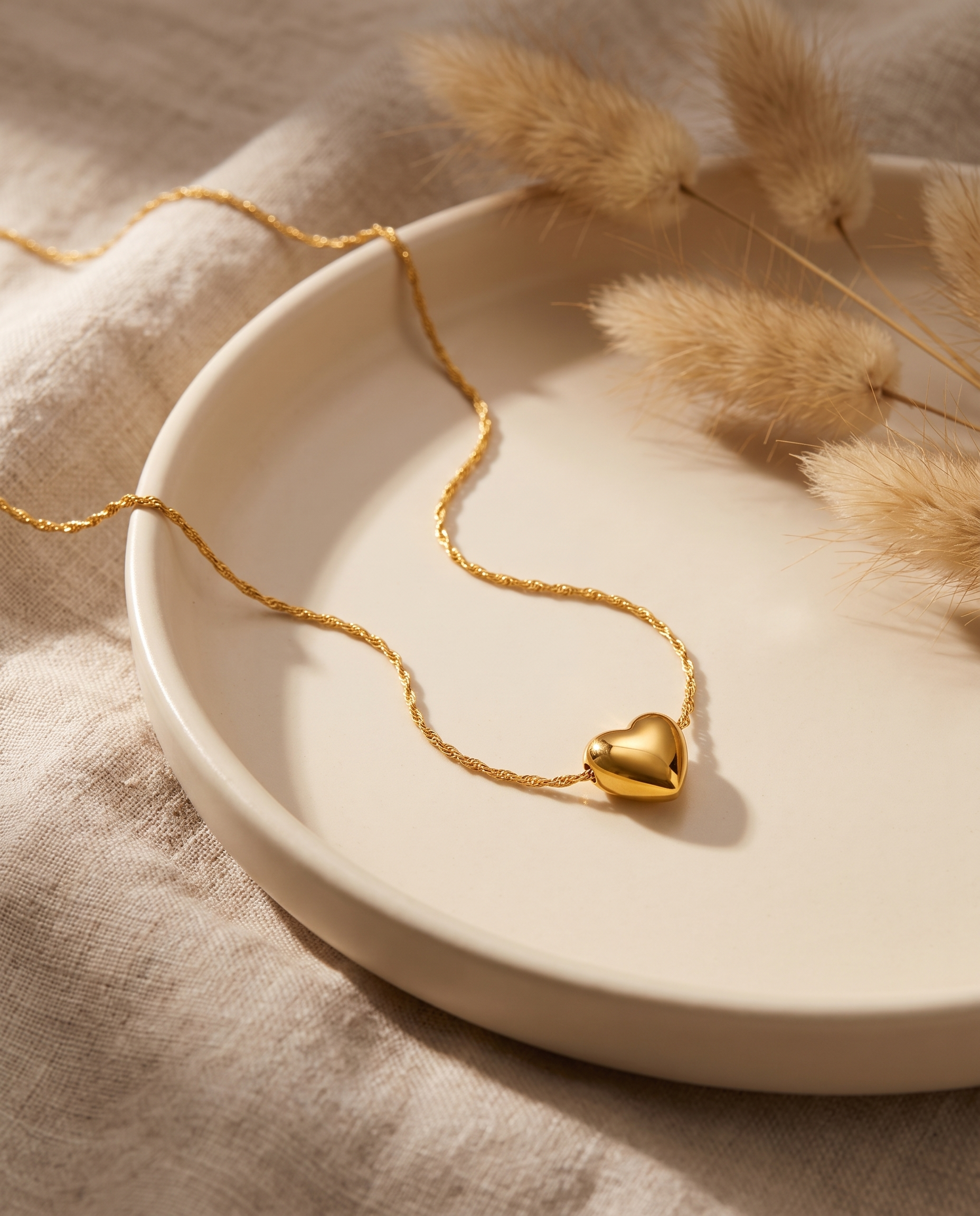 Collier Cœur Puffy présenté sur coupelle avec pampa