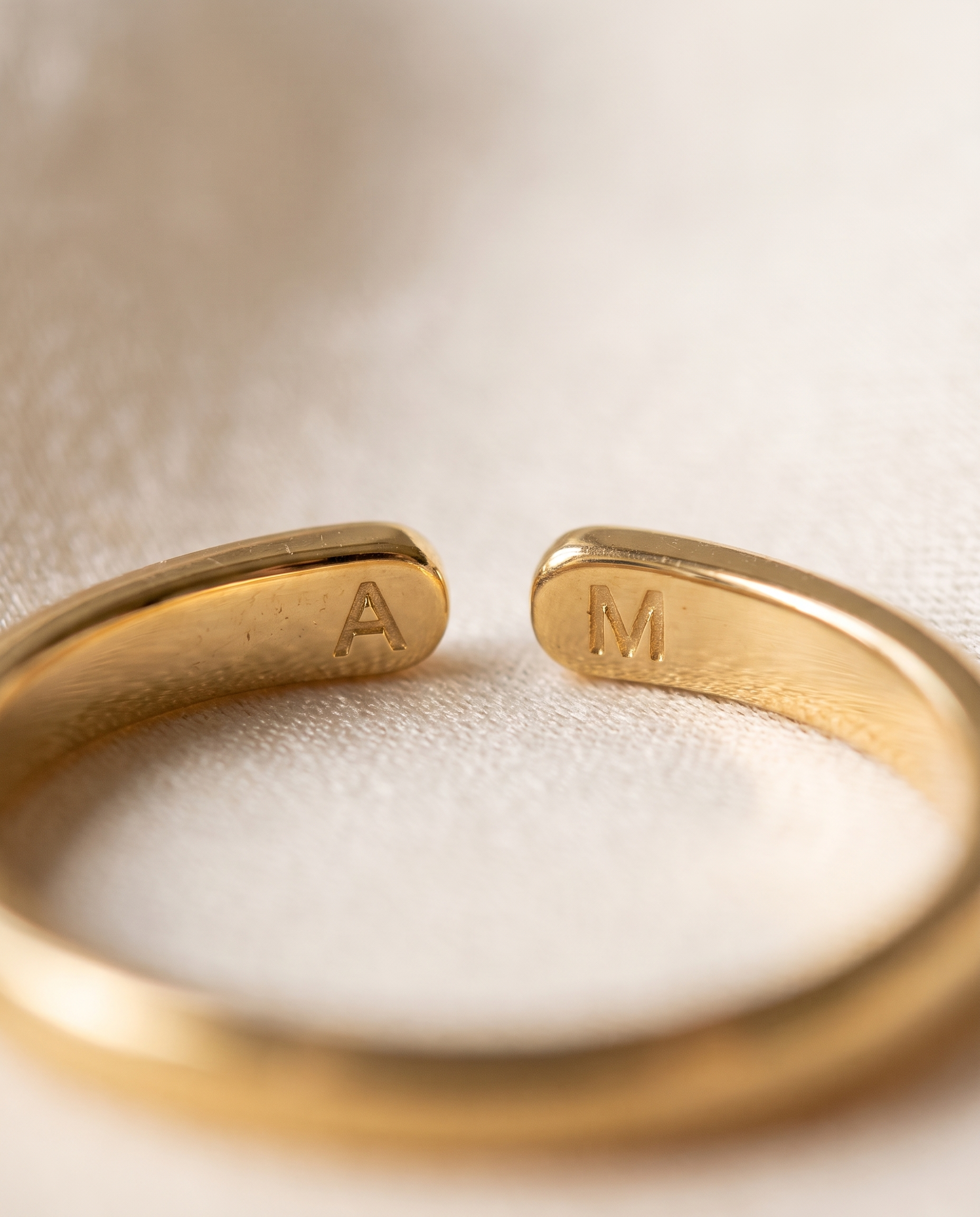 Gros plan des deux initiales gravées sur la bague Whisper