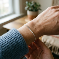 Bracelet Code Morse argenté porté au poignet